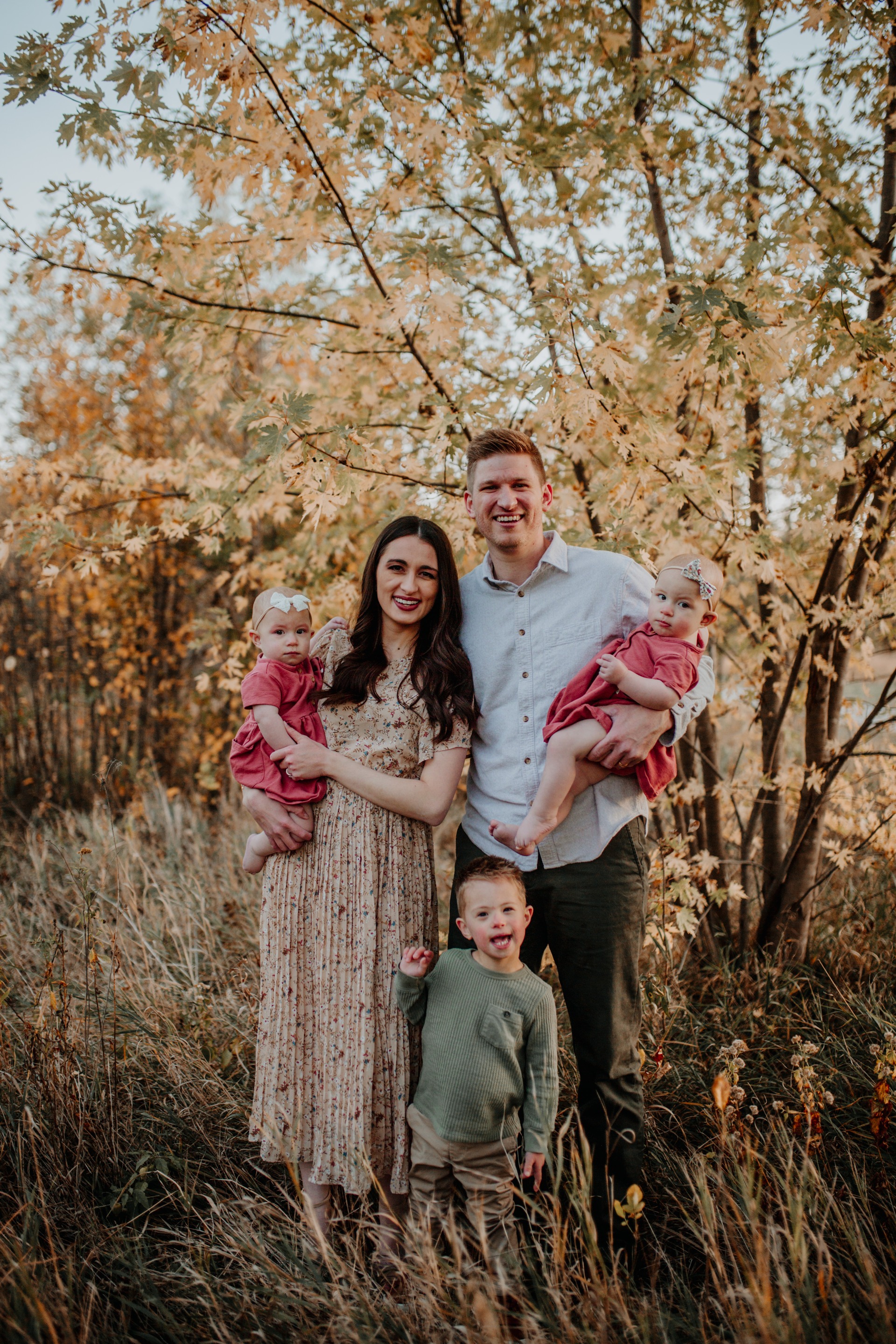 Dr. Richardson standing in front of an autumn tree with her three children and husband.